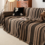 Cafe Noir Metro Stripe throw covering a sofa in a warm living room with wood cabinet, floral cushion and tray