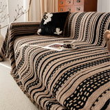 Cafe Noir Metro Stripe throw over a sofa, angled view with a coffee cup on a tray and dark floral cushion