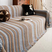 Slate Blue Metro Stripe throw styled on a sofa with a dark floral cushion and coffee cup