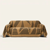 Savanna Earth Modern Jungle throw draped over a two-seat sofa on ivory background