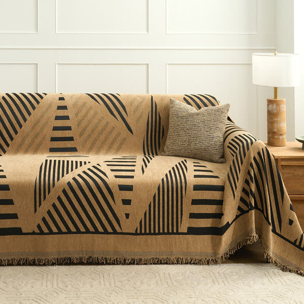 Camel savanna throw with black lines covering a sofa with cushion and wood lamp table