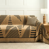 Camel savanna throw with black lines covering a sofa with cushion and wood lamp table