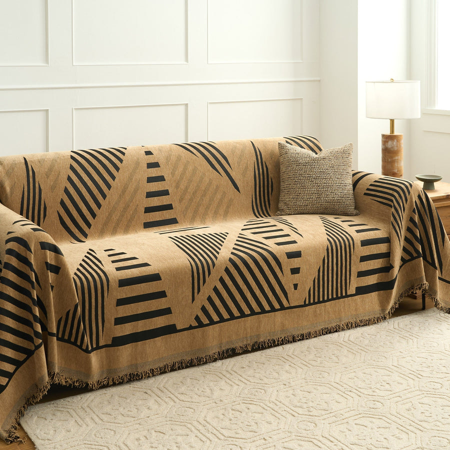 Savanna earth throw over a sofa with textured cushion beside a panelled wall