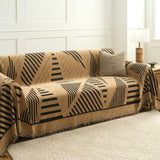 Savanna earth throw over a sofa with textured cushion beside a panelled wall