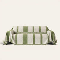 Forest green Modern Stripe sofa throw draped over a couch, front view on an ivory backdrop with fringe