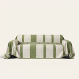 Forest green Modern Stripe sofa throw draped over a couch, front view on an ivory backdrop with fringe