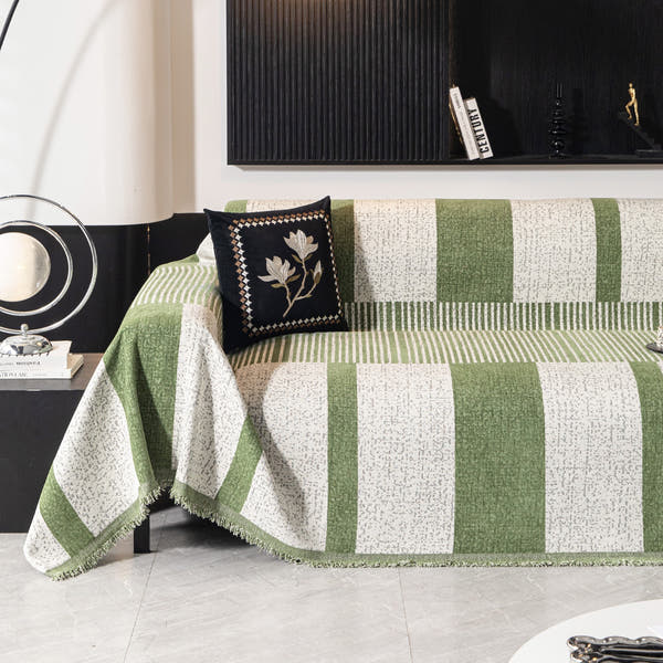 Forest green Modern Stripe throw styled on a sofa with a black floral cushion, green and cream stripes