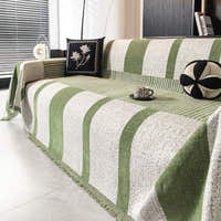 Angled view of the Modern Stripe forest green throw over a sofa with cushions and a coffee cup