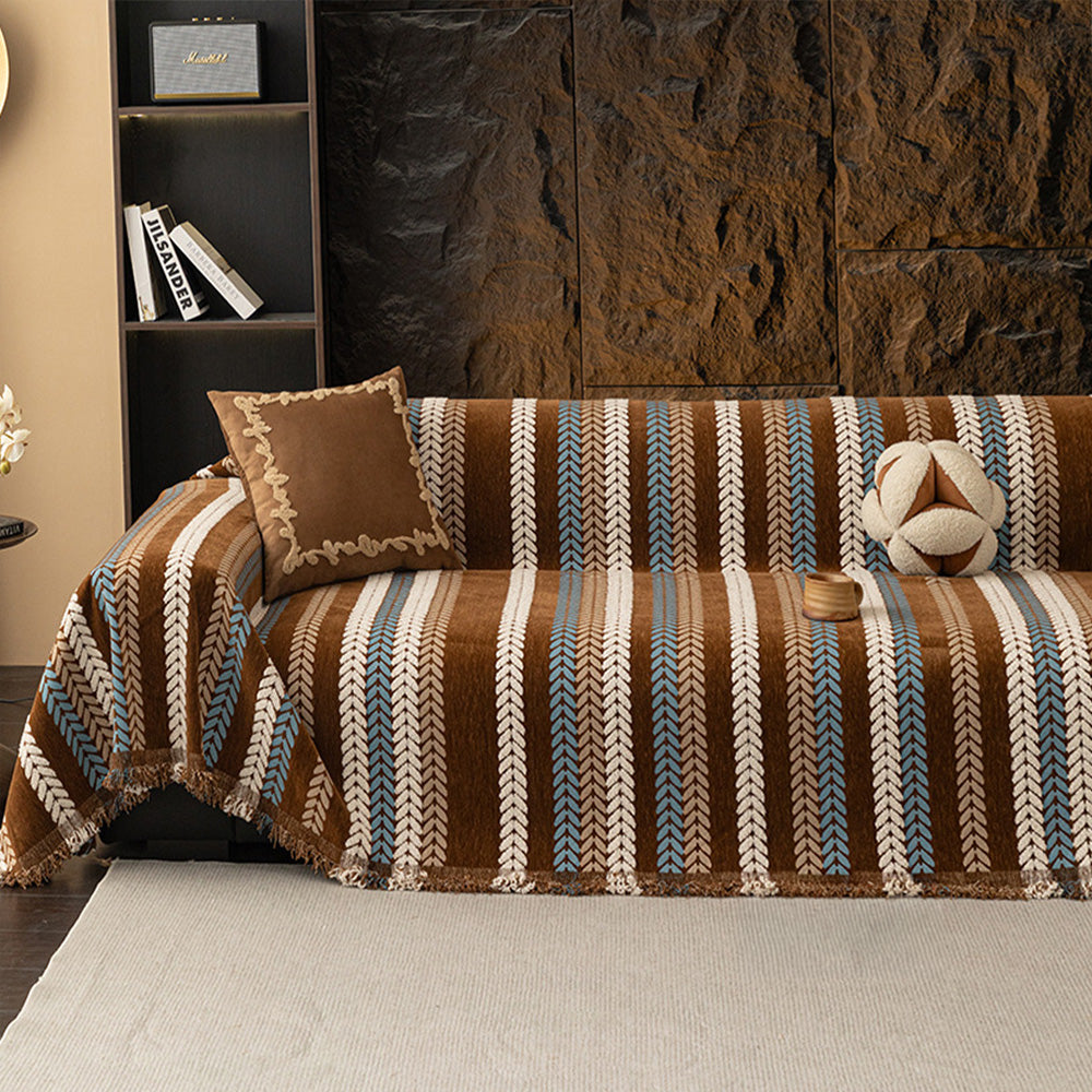 Caramel Sky Modern Striped throw covering a sectional sofa against a stone wall with suede cushion and shelving