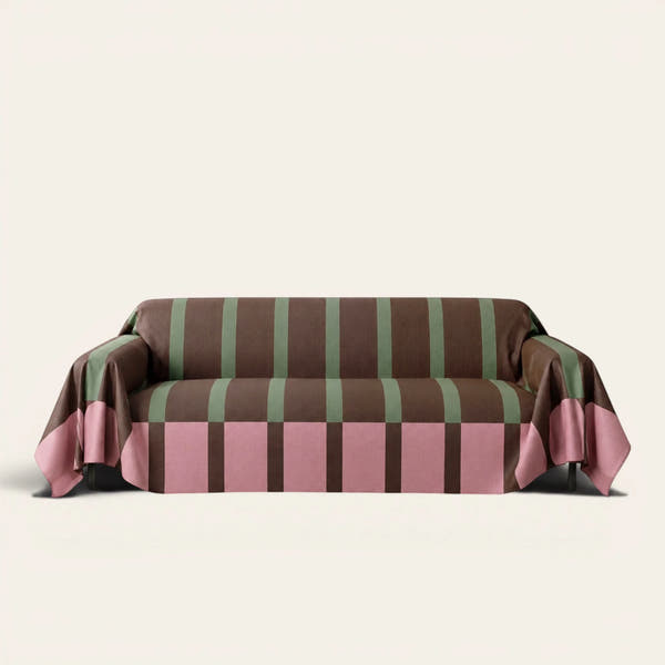 Modern Striped Mocha Rose sofa throw draped over a three-seat sofa, front view on ivory
