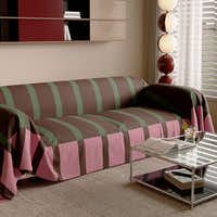 Modern Striped Mocha Rose throw on a sofa, angled view beside a glass side table and window