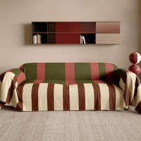Olive Rust Modern Striped throw styled on a sofa with wall shelf and jute rug