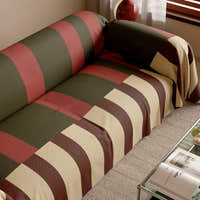 Close view of the Olive Rust Modern Striped throw over a sofa seat beside a glass table