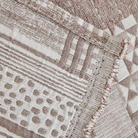 Close-up of Latte Beige Modern Washed throw, woven geometric patchwork motifs with a fringed edge