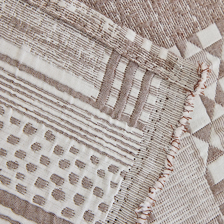 Close-up of Latte Beige Modern Washed throw, woven geometric patchwork motifs with a fringed edge