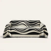 Modern Wave Monochrome Wave sofa throw draped over a three-seat sofa, front view on ivory