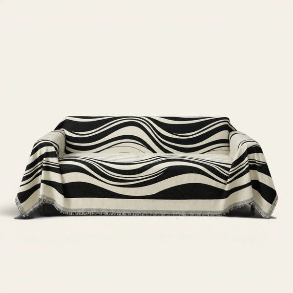 Modern Wave Monochrome Wave sofa throw draped over a three-seat sofa, front view on ivory
