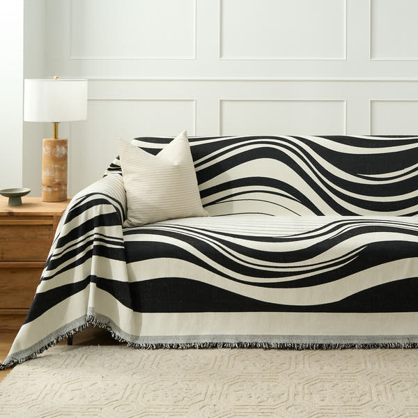 Monochrome Wave Modern Wave throw styled on a sofa with cream cushion and wood side table
