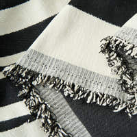 Close-up of the fringed corner of the Modern Wave Monochrome Wave throw