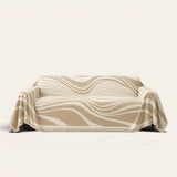 Sandy Drift Modern Wave throw draped over a two-seat sofa on ivory background