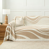 Sandy drift wave throw covering a sofa with boucle cushion and wood lamp table
