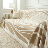 Modern wave throw on a sofa with boucle cushion and lamp in a bright room