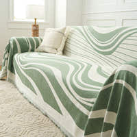 Verdant Flow Modern Wave throw styled on a sofa with a cushion beside a window