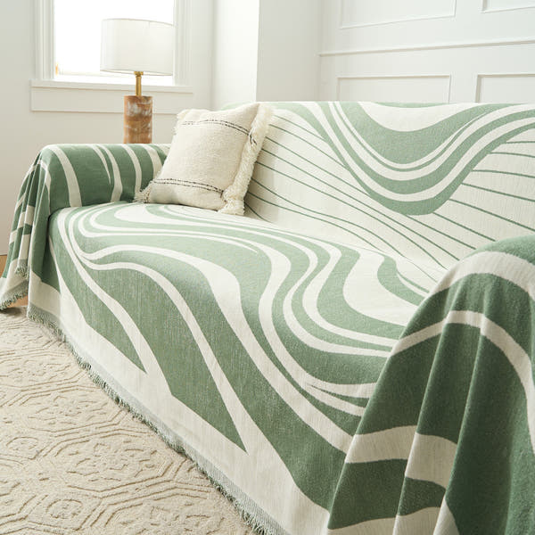 Verdant Flow Modern Wave throw styled on a sofa with a cushion beside a window