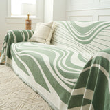 Verdant Flow Modern Wave throw styled on a sofa with a cushion beside a window