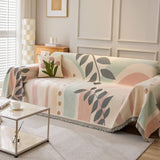 Angled view of the Natural Botanical garden arch throw over a sofa showing pastel arch and leaf motifs