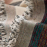 Macro close-up of the garden arch throw's woven texture and knotted fringe with colorful threads