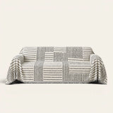 Sightline Stripes Monochrome Stripe sofa throw draped over a three-seat sofa, front view on ivory
