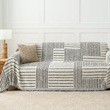 Monochrome Stripe Sightline Stripes throw styled on a sofa with woven cushion and wood side table