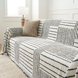 Sightline Stripes Monochrome Stripe throw on a sofa, angled view with a textured beige cushion