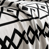 Close-up of the monochrome diamond pattern and woven folds of the Black Bohemia throw