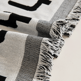 Macro of the black and white fringed tasseled edge of the Sleek Boho throw