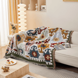Sunflowers Fantasy throw in Ivory Blooms over a sofa by a floor lamp and window, angle view