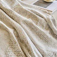 Detail of the draped mosaic throw folds with fringed edge