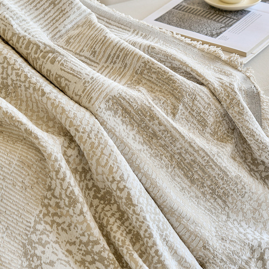 Detail of the draped mosaic throw folds with fringed edge