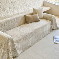 Textured mosaic throw on a sofa styled with two beige cushions, viewed from above