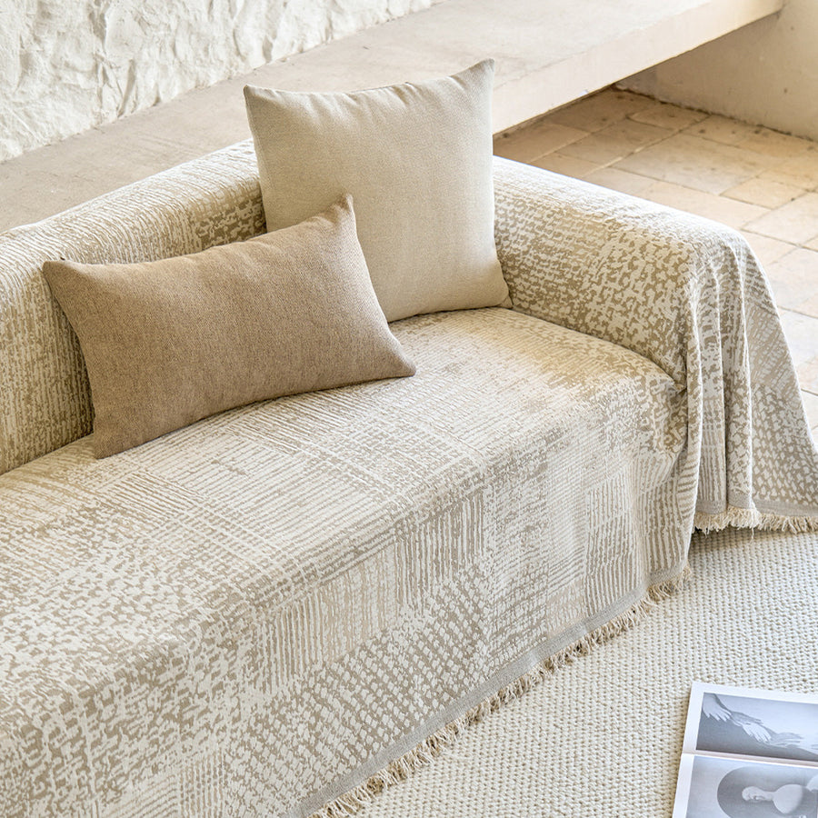 Sand beige mosaic throw on a sofa seat with beige lumbar and square cushions