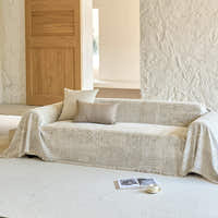 Sand beige mosaic throw over a sofa in a bright room with wood door and cushions