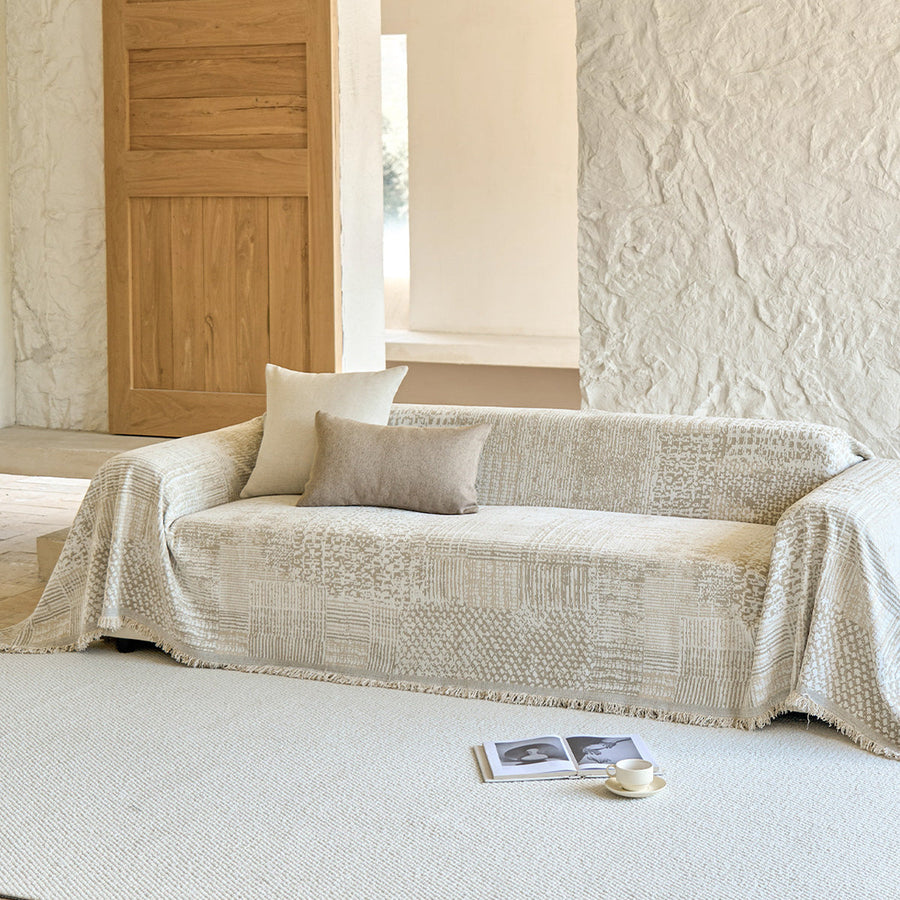 Sand beige mosaic throw over a sofa in a bright room with wood door and cushions