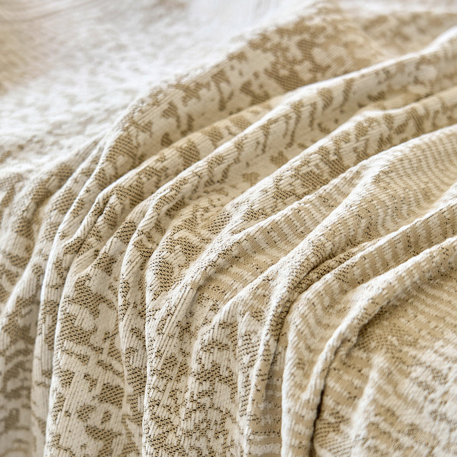 Macro of the sand beige fabric folds showing the tonal mosaic pattern
