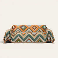 Rust Green Tribal Charm throw draped over a two-seat sofa on ivory background