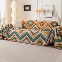 Rust green tribal throw on a sofa with textured cushion, framed art and lamp