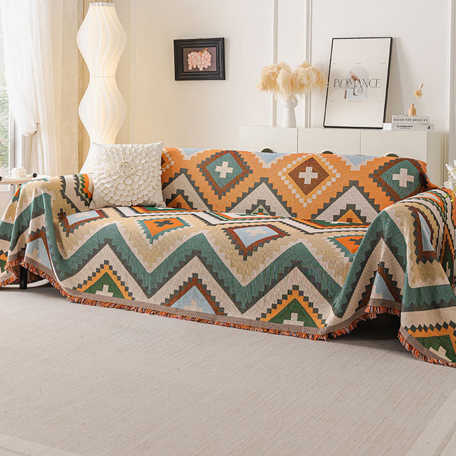 Rust green tribal throw on a sofa with textured cushion, framed art and lamp