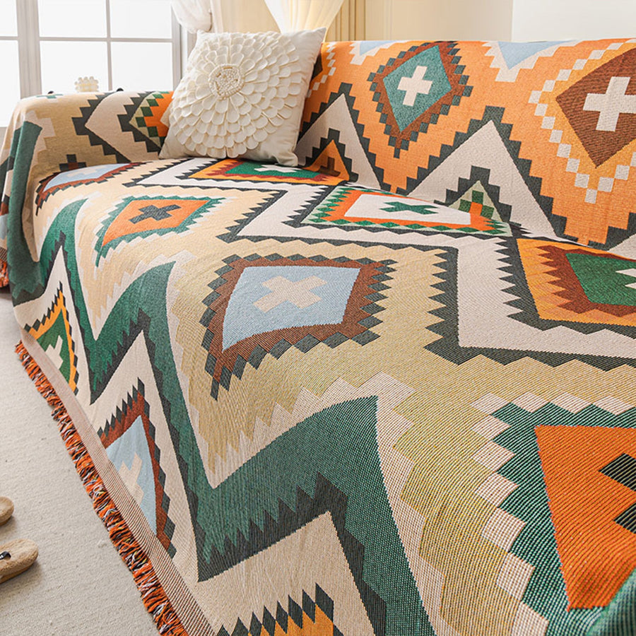 Rust green tribal throw styled over a sofa with white cushion beside a window