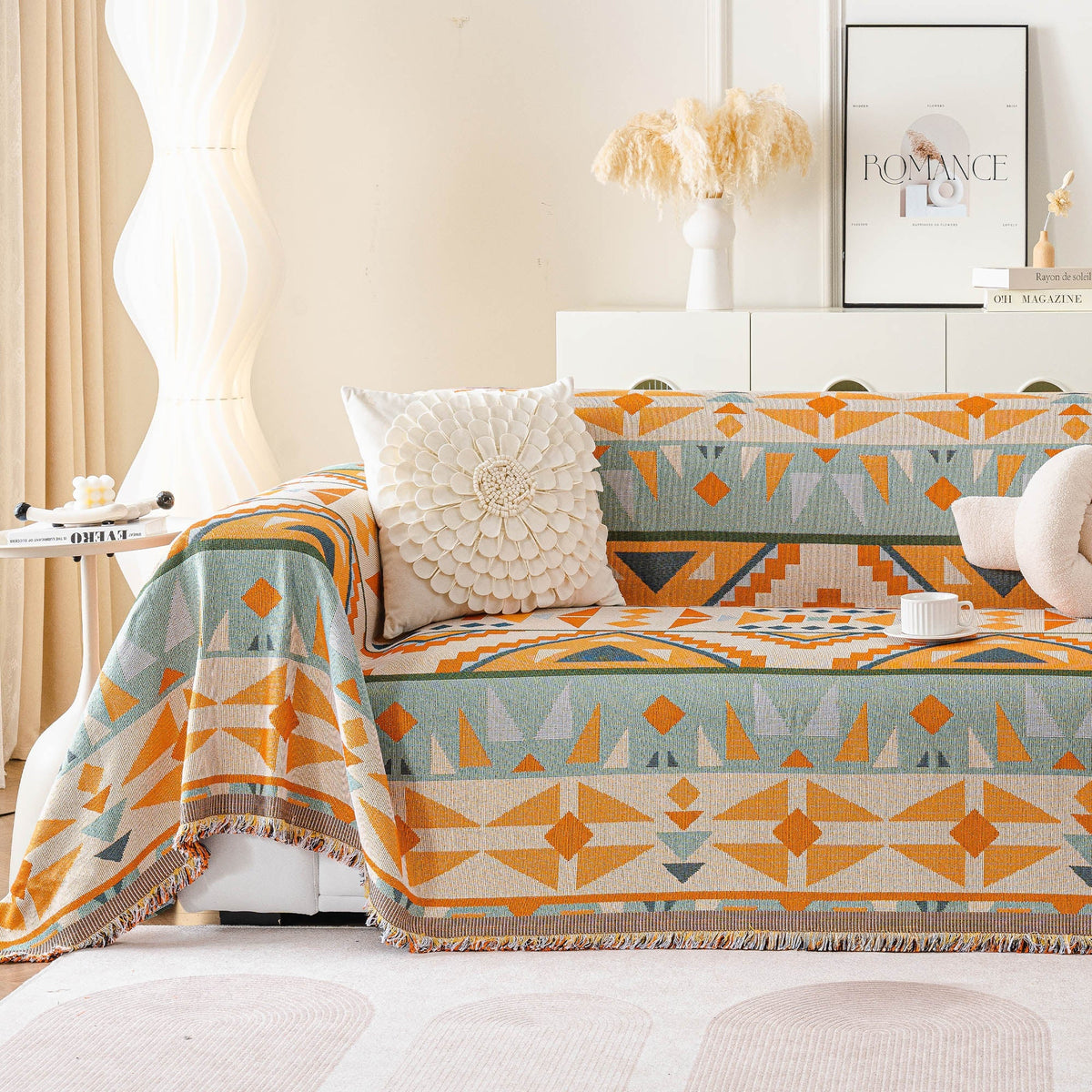 Tribal Sunset amber sage geometric sofa throw styled on a sofa with a textured flower cushion in a bright living room