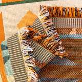 Macro detail of the tribal sunset sofa throw fabric, woven texture and tasseled fringe
